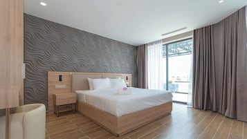 Ein modernes Hotelzimmer mit einem großen Bett, einem Nachttisch und einem Fenster mit Vorhängen.