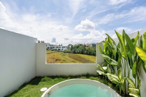 A small, private outdoor area with a hot tub, a view of a rice field, and lush greenery. - Inhale Loft Villa by Betterplace (Canggu)
