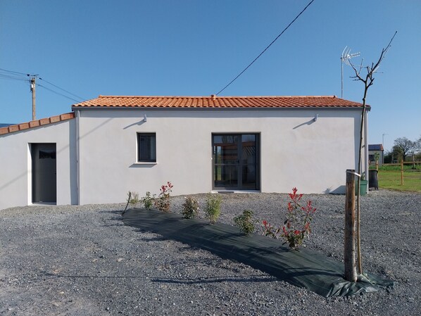 A modern building with a tiled roof, a small window, and a door.