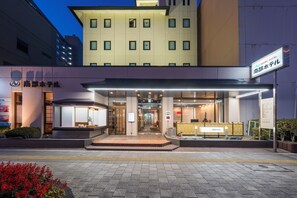 Ingresso di un hotel con portico, reception e insegna con il nome dell'hotel.