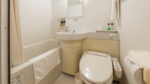 A compact bathroom with a white sink, a toilet, and a bathtub. - nanbuhotel (Kitakami)