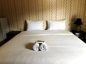 A neatly made bed with white linens, two pillows, and rolled towels on the bed. - Sutus Court 7 (Pattaya)