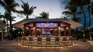 Un espace bar extérieur doté d’un aménagement circulaire avec des sièges disposés en cercle autour d’un bar central.