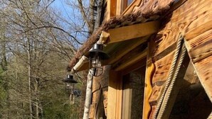 Une cabane en bois avec une terrasse, une table et des chaises.