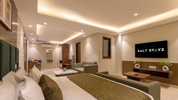 Une chambre d’hôtel moderne équipée d’un grand lit, d’une télévision, d’un bureau et d’un canapé.