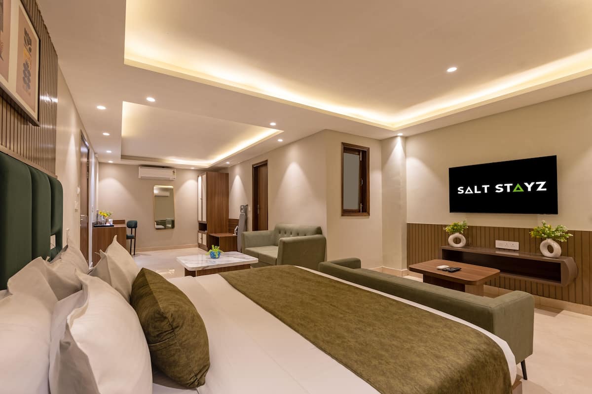 Une chambre d’hôtel moderne équipée d’un grand lit, d’une télévision, d’un bureau et d’un canapé.