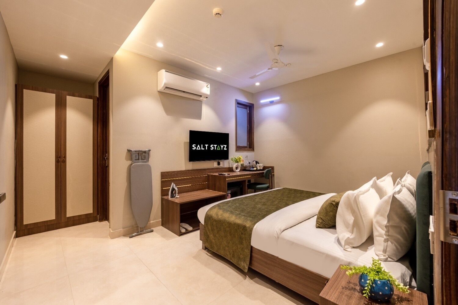 Ein modernes Hotelzimmer mit Bett, Schreibtisch und Fernseher.