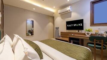 Ein Hotelzimmer mit einem Bett, einem Schreibtisch, einem Fernseher und einer Klimaanlage.
