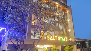 Un bâtiment moderne avec l’enseigne « Salt Stayz » illuminée la nuit.