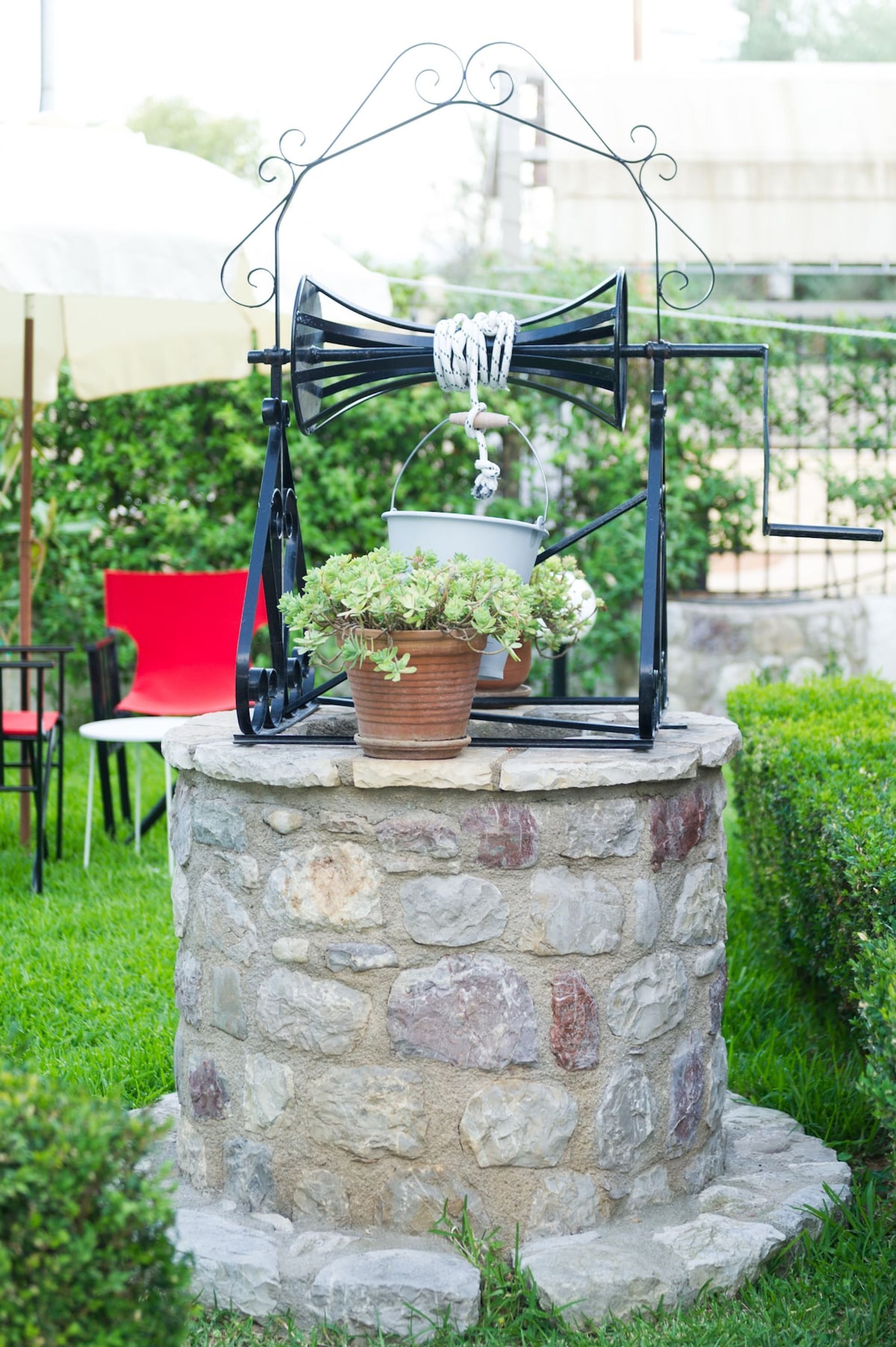 A stone structure with a metal frame and potted plants.