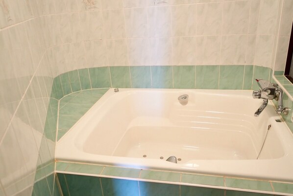 Une salle de bain avec une baignoire, une douche et des toilettes.