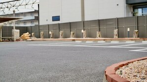 Ein Parkplatz mit einem Gebäude im Hintergrund.