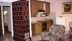 A living room with a patterned armchair, a wooden cabinet, and a tiled wall unit. - Apartments Miloš (Malinska-Dubasnica)