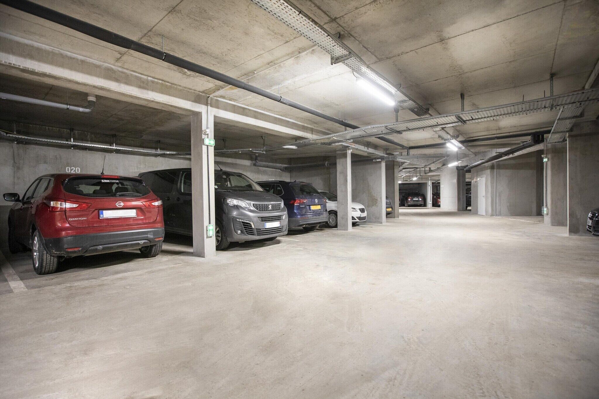 A multi-level parking garage with concrete pillars and overhead lighting.