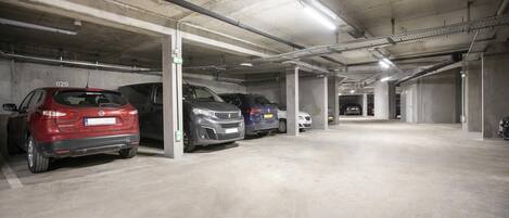 A multi-level parking garage with concrete pillars and overhead lighting.