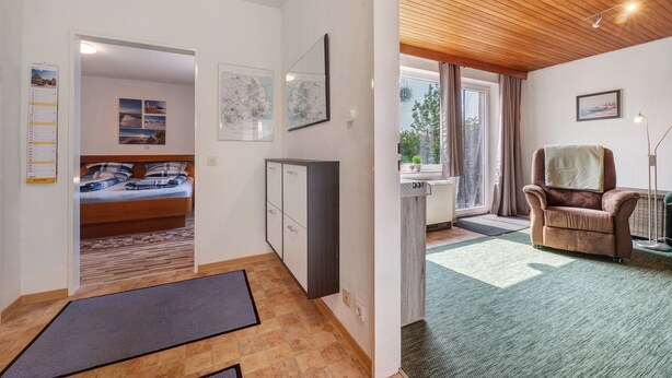 A room with a bed, a desk, a chair, and a view of the outdoors. - Apartment 'Haus Meyer' with Private Terrace, Private Garden and Wi-Fi (Cuxhaven)