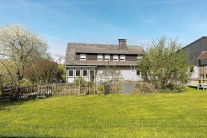 A house with a sloped roof, a fenced yard, and a satellite dish. - Apartment 'Gänseblümchen' with Private Terrace, Shared Garden and Wi-Fi (Schmallenberg)