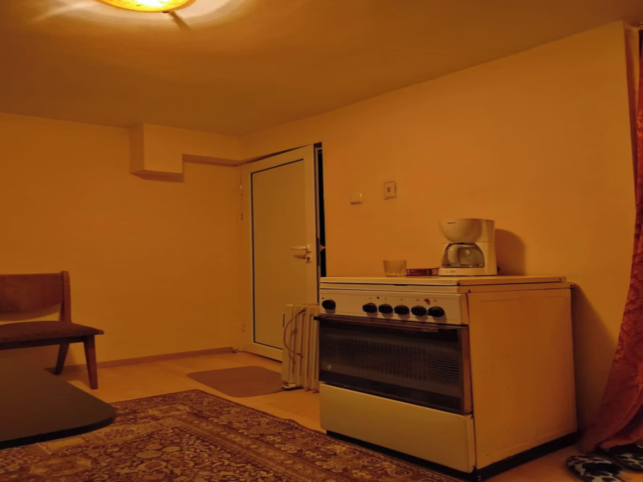 Una cocina funcional con estufa, horno y cafetera.