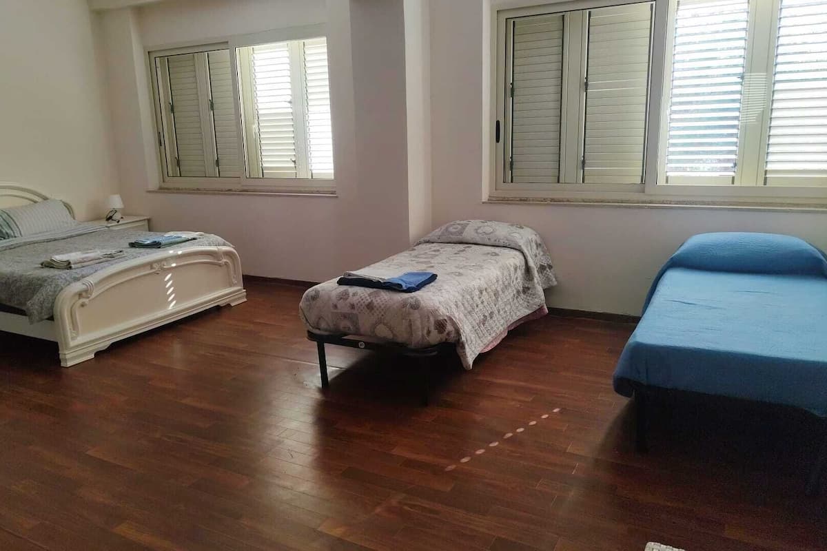 Ein Schlafzimmer mit zwei Betten, einem Nachttisch und einem Fenster mit Jalousien.