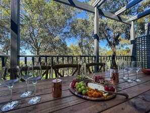 A wooden table set outdoors with a view of trees and sky. - Villa Amore - Two-storey villa at Cypress Lakes Resort (Pokolbin)