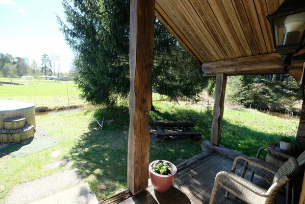 Eine Holzterrasse mit einem Korbstuhl und einem Blumentopf.