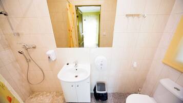 Un baño con lavamanos, inodoro y ducha.