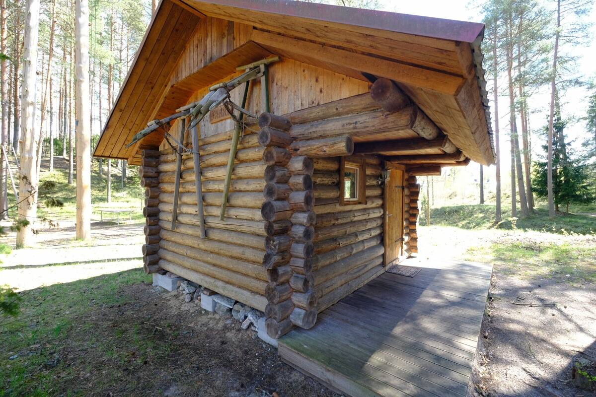 Una cabaña de madera con fachada de madera, techo inclinado y una ventana pequeña.