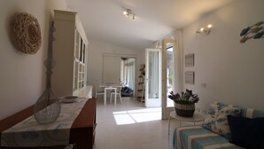 Uma sala ampla com uma mesa de jantar, um sofá e um objeto decorativo na parede.