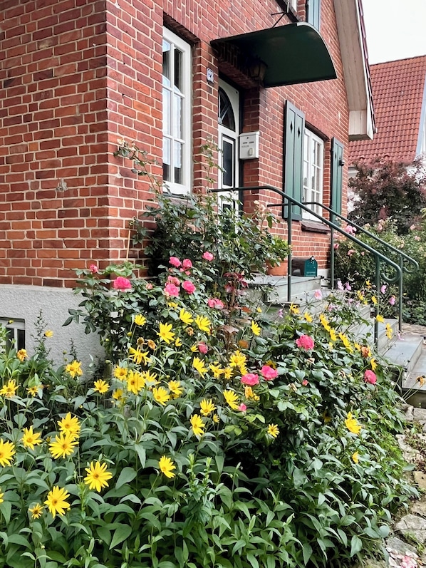 A red brick building with a green awning and a metal staircase.