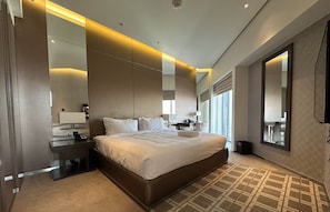 Relax in a spacious room with a large bed, nightstand, and mirror.