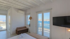 Une chambre à coucher avec un lit, une télévision, une fenêtre donnant sur un beau paysage et un ventilateur de plafond.