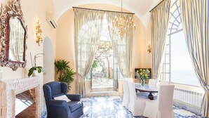Una habitación con chimenea, una mesa de comedor con sillas, un candelabro y vistas al exterior.