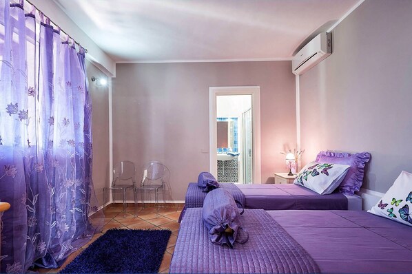 A bedroom with a bed, a nightstand, a lamp, and a window with curtains. - Casa Tika with shared pool - My Rental Homes (Marsala)