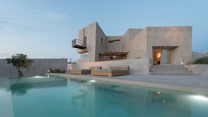 Ein modernes Haus mit Schwimmbad, Balkon und kleinem Garten.