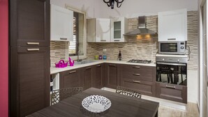 A modern kitchen with dark wooden cabinets, a gas stove, a microwave, and a built-in oven.