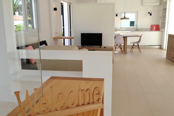 A modern living room with a TV, sofa, and a 'Welcome' sign. - My Rental Homes - Nure Villa 2 with private pool, air conditioning and wifi (Ciutadella)