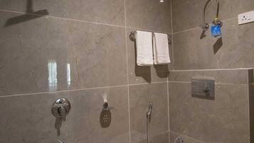 A modern bathroom with a shower, toilet, and a towel rack.