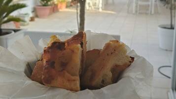 Una mano che tiene un piatto di carta con un pezzo di pane.