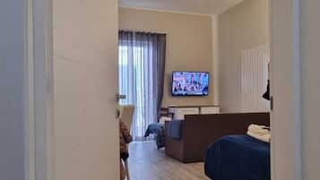 Habitació quàdruple Deluxe, balcó | Espai de treball apte per a portàtils i planxa i posts de planxar