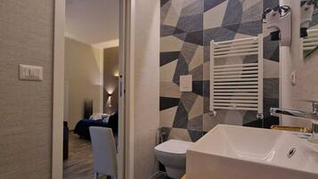 Habitación cuádruple Deluxe, balcón | Espacio para trabajar con un portátil y tabla de planchar con plancha