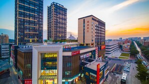 Een modern hotel met meerdere verdiepingen, een opvallend McDonald's bord en uitzicht op de omliggende stad.
