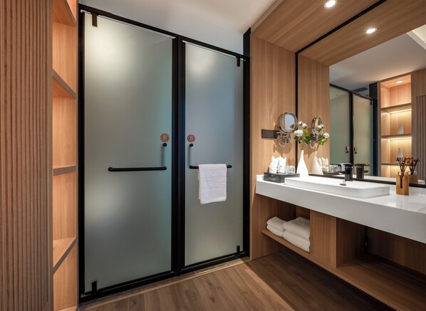 Un bagno moderno con uno specchio grande, due lavabi e un porta asciugamani.