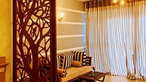 A living room with a sofa, a coffee table, a decorative wooden partition, and a ceiling fan with lights. - New Casa Marc (Induruwa)