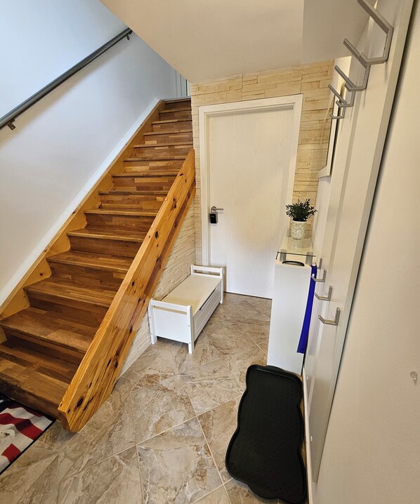 Un escalier avec des marches en bois et une porte blanche en haut.