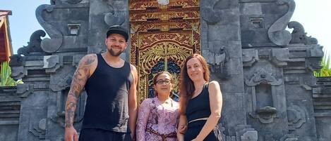 Un grupo de personas frente a una construcción de piedra con intrincados grabados y una puerta grande y ornamentada.