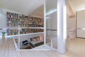 Un interno moderno con camera da letto in stile loft, una grande libreria e un design minimalista.