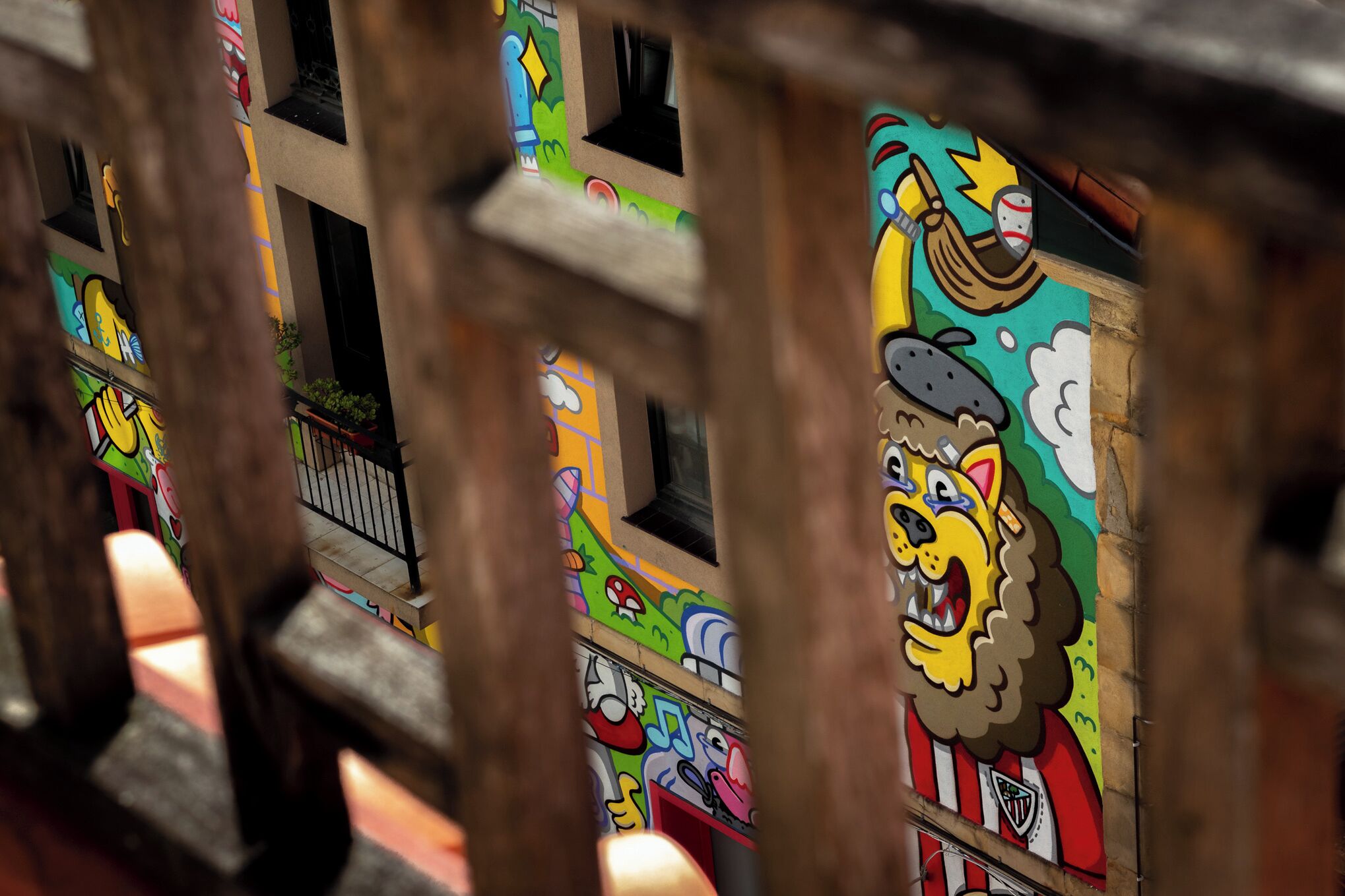 Fachada de edificio con murales coloridos, incluyendo una destacada figura de león.