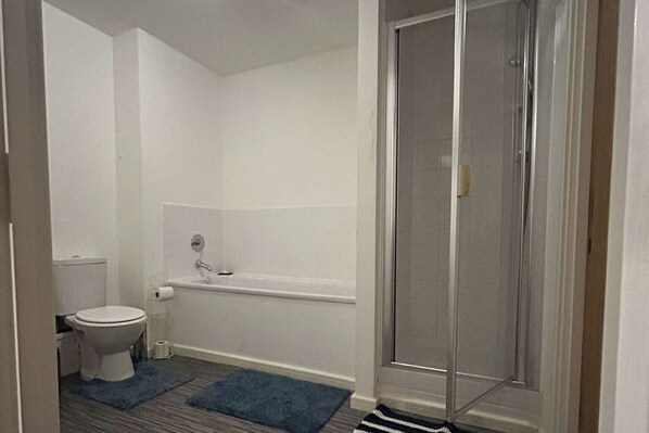Ein Badezimmer mit Toilette, Badewanne und Dusche.