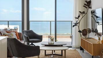 A modern living room with a large window, a round coffee table, and a sofa.