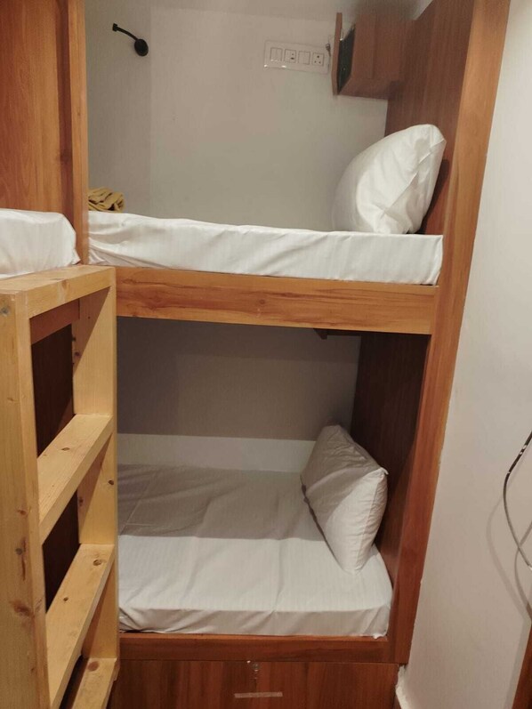 A bunk bed with wooden frames and white bedding. - HOTEL AMAR RESIDENCY  (Mumbai)